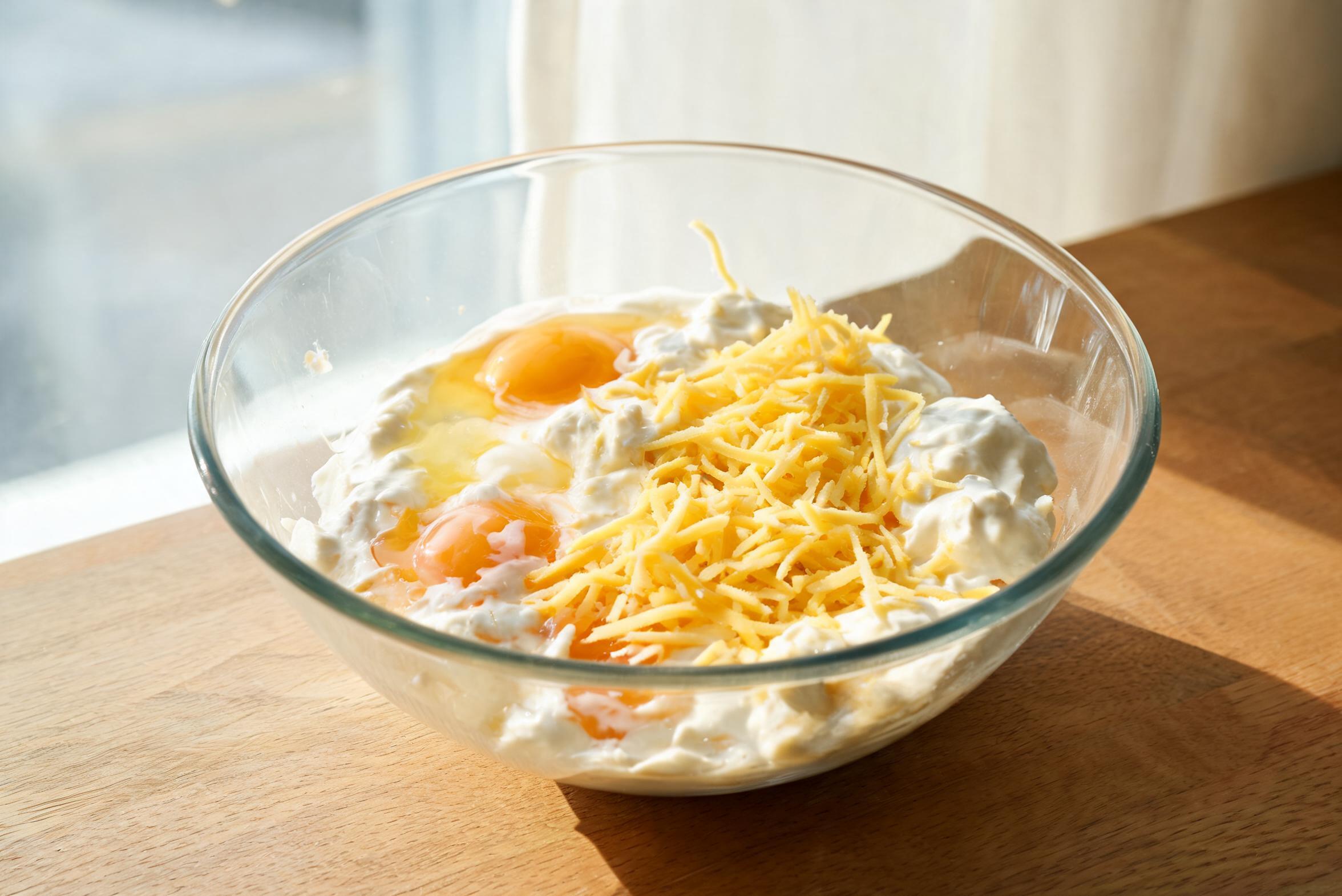 Сметанная смесь с яйцами и сыром в миске